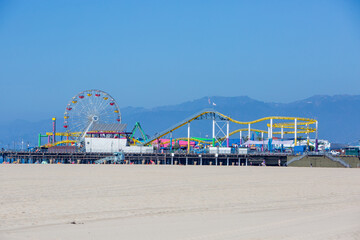 Photo for Pacific Park with Ferris Wheel on the Santa Monica Pier over Beach Sand on Bright Sunny Daytime