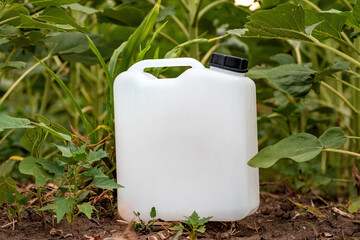 Blank mockup white plastic jug for herbicide chemical in cultivated sunflower field
