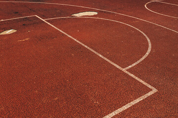 Worn damaged outdoor basketball court surface