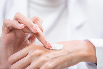 Obraz na płótnie Canvas Beauty cosmetic research and development concept, Pharmacist and Scientist applying moisturizer lotion on her hand for efficacy testing of natural organic skincare products in biological laboratory