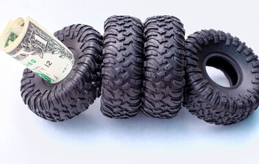 winter rubber black tire toy car wrench plastic key and one two dollar bills isolated mockup free space for text.tire change replacement summer winter season auto service concept payment saving money