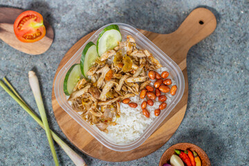 rice bowl with spicy chicken and fried peanuts with cucumber