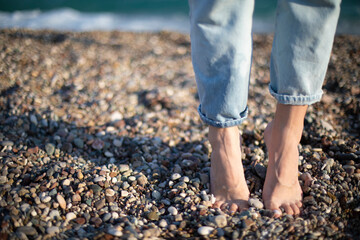Barefoot massage grounding healthy step on a stone beach seaside. Relaxing vacation photo women...