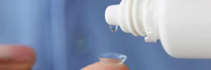 Woman with contact lenses drips moisturizing solution