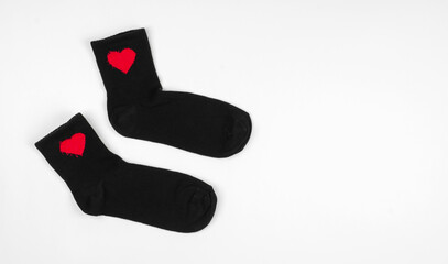 Black socks on a white background. Pair of black socks with hearts
