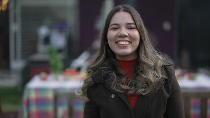 Fototapeta premium One young casual woman standing outside with coat. Portrait of a South American latin 20s girl