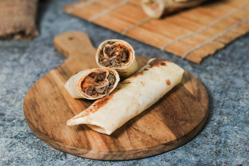 A delicious doner donair kebab wrap with spicy meat lettuce tomato red onion and sauce