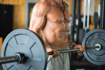 Anonymous strong man lifting weights in a gym