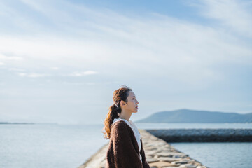 Fototapeta premium 夕暮れの海にいる女性
