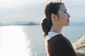 夕暮れの海にいる女性