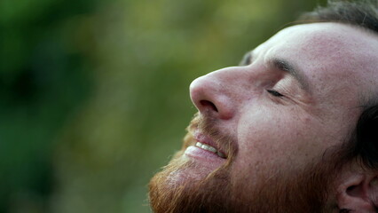 Fototapeta premium Grateful man closing eyes in meditation. Person opening eye to sky with HOPE and FAITH. Spiritual person smiling in contemplation
