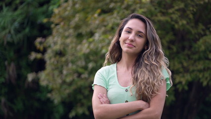 Diverse South American young woman portrait face. 20s latina girl crossing arms smiling at camera