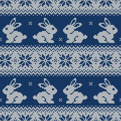 Knitted seamless pattern for 2023 new year of the rabbit. Vector background with cute bunnies and scandinavian ornaments. Dark blue and white sweater print.