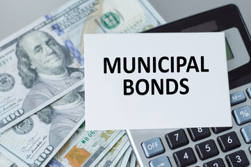 municipal bonds text on the card next to the calculator and money on the table