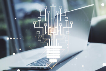 Creative light bulb with chip hologram on modern laptop background, artificial Intelligence and neural networks concept. Multiexposure