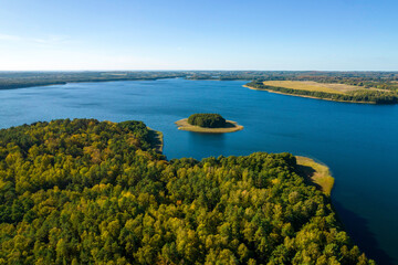 Widok z drona na jezioro Wierzchowo w Polsce. Zielony las otaczający jezioro i czysta niebieska...