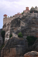 Fototapeta na wymiar This curly stairway cut into imposing Meteora solid rock leads t o the entrance of the second largest historical complex of Holy Varlaam Monastery, Trikala, Thessaly, Greece, vertical photo