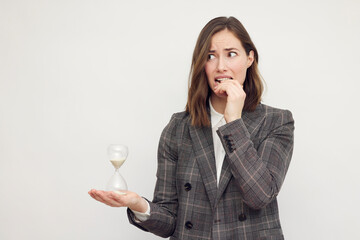Young stressed business woman holding one hand palm up with hourglass. Concept: Time and stress at...
