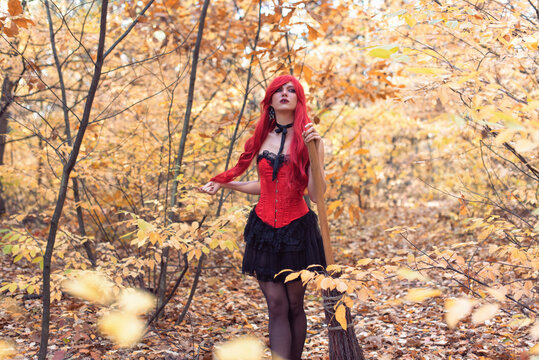 Young witch in autumn forest
