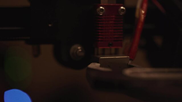 Unscrewing the nozzle of the 3D printer from the hotend extruder with wrenches