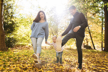 happy family with little daughter in autumn park outdoor recreation.