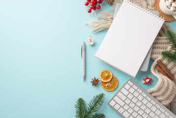 Top view photo of notebook pen keyboard cup of hot drinking knitted plaid pine branches mistletoe berries decorative clips dried citrus slices cinnamon on isolated light blue background with copyspace
