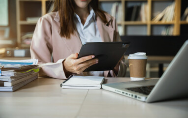 Business concepts, business woman working in the work area with tablet and data sheets at the desk.