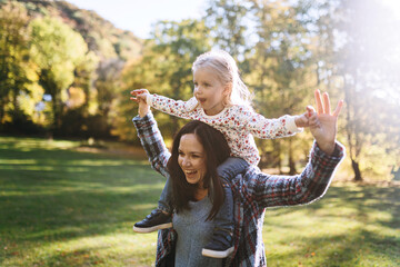 happy mom with little daughter in autumn park outdoor recreation. Mom and daughter