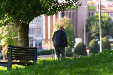 Old man with a cane walking in a park
