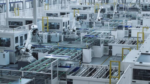 Time-lapse video of Large Solar Panel Automated Production Line with Industrial Robot Arms. Looped video. Modern, Bright Manufacturing Facility.