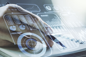 Multi exposure of abstract statistics data hologram interface with man hand writing in notepad on...