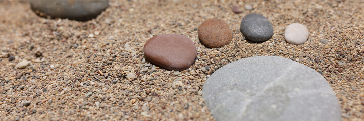 Fototapeta na wymiar Footprint of stones in the sand, close-up, blurry