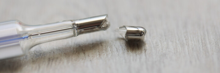 Broken mercury thermometer on a gray background, blurry