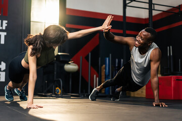 Young athlete male and fitness trainer female friends workout in gym. 