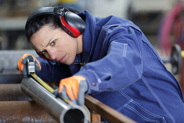 portrait of two factory worker measuring a pipe