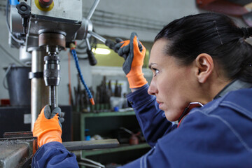 female factory worker operating machine