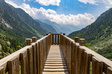 The wood bridge over the Toce waterfall in Formazza Valley, province of Verbano-Cusio-Ossola, Italy. With a jump of 143 meters it is the second highest waterfall in Europe