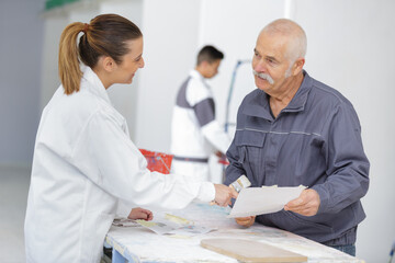 Fototapeta premium woman signing document with male painter at home