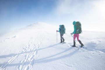 Two women walk in snowshoes in the snow