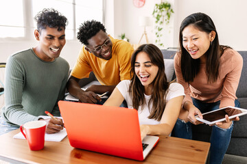 Young group of diverse students studying together using laptop at home - College multiracial people working on university group assignment homework project in modern apartment - Powered by Adobe