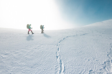 two tourists in winter mountains on snowshoes