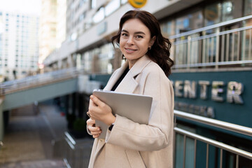 Business woman with a laptop in her hands on the background of the city