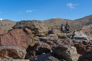 hikers surrounded by rocks observe the landscape in Sierra Nevada