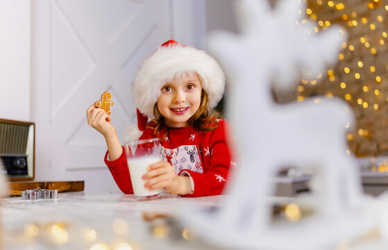 Child in Santa hat taste freshly made cookies in anticipation of Christmas Eve. - Powered by Adobe
