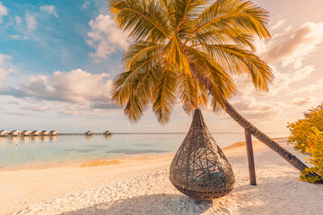 Entspannen Sie sich im Urlaub, Freizeit-Lifestyle am exotischen tropischen Inselstrand, Palmen-Hängematte, die ruhiges Meer hängt. Paradiesische Strandlandschaft, Wasservillen, Sonnenaufgangshimmel bewölkt erstaunliche Reflexionen. Schöne Natur © icemanphotos
