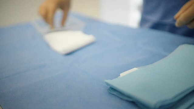 Operating theater staff laying tools out on medical trolley ready for operating. .