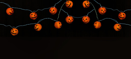 Happy HALLOWEEN party celebration background banner Panorama - Fairy lights, String of lights with funny orange glowing Halloween pumpkins in the dark night