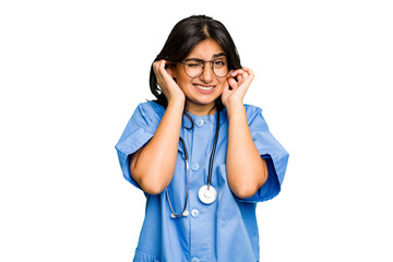 Young nurse Indian woman isolated covering ears with hands.