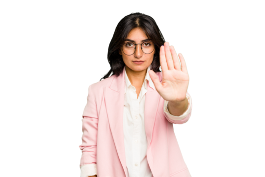 Young Indian business woman wearing a pink suit isolated standing with outstretched hand showing stop sign, preventing you.
