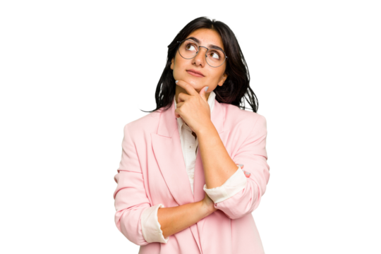Young Indian business woman wearing a pink suit isolated looking sideways with doubtful and skeptical expression.